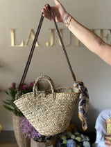 Straw bag with blue colored shoulder strap