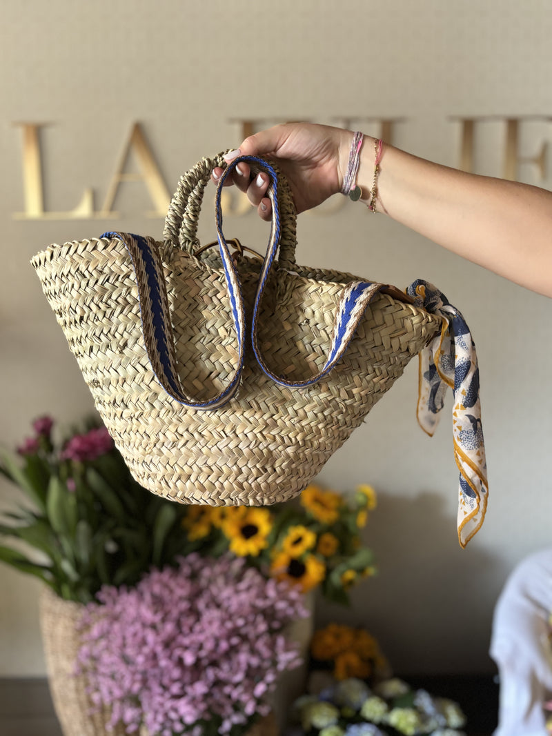 Straw bag with blue colored shoulder strap